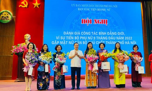 Phó Chủ tịch UBND thành phố Chử Xuân Dũng, Trưởng ban Vì sự tiến bộ phụ nữ thành phố Hà Nội tặng hoa các nữ cán bộ chủ chốt thành phố.